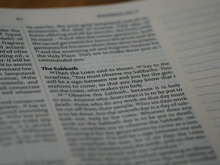 A detailed close-up of an open Bible showing a passage about the Sabbath.