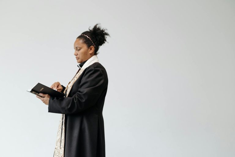 A female pastor reading a Bible indoors, showcasing faith and spirituality.